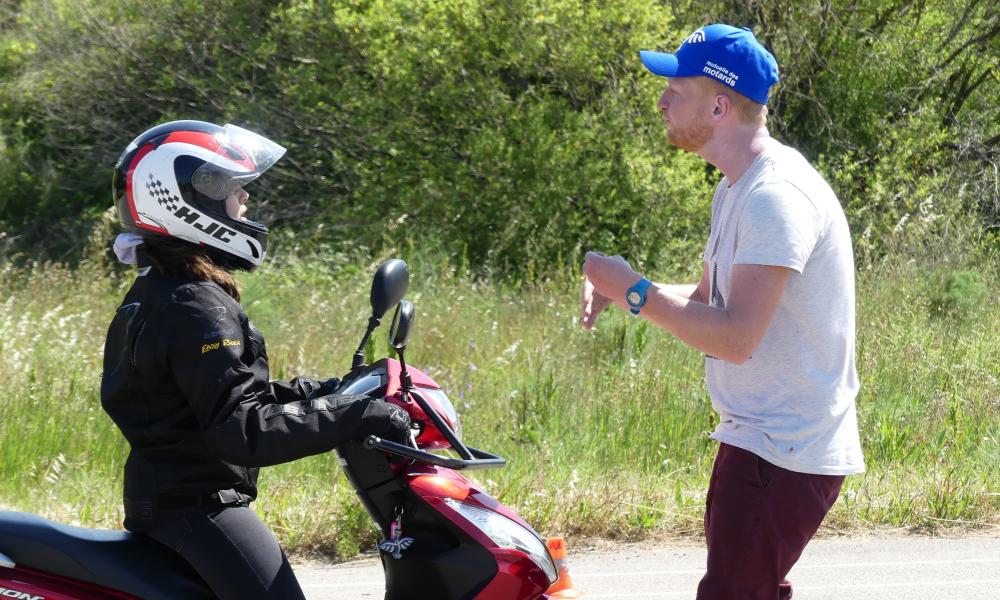 Moniteur donnant conseils à jeune motarde